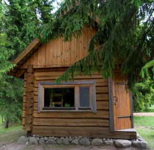 a log cabin with a window on the side of it at Ansomäe Puhkeala Järvemaja in Otepää