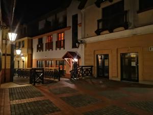 an empty street at night with a building at A3 - APARTAMENTY in Mikołajki