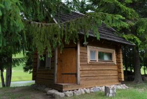 a small log cabin with a window and a door at Ansomäe Puhkeala Järvemaja in Otepää +12 photos