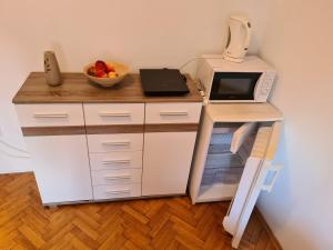 una pequeña cocina con microondas y nevera. en Michael's, en Zadar