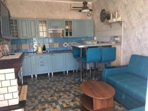 カバルジンカにあるPrivate House Kalipsoのキッチン(青いキャビネット、青いソファ、テーブル付)