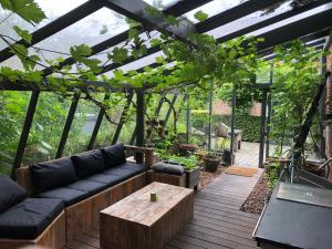 a greenhouse with a couch and a coffee table in a patio at B&B Vennehoeve in Vremde