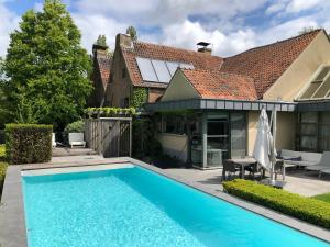 a swimming pool in front of a house at B&B Vennehoeve in Vremde