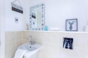 a white bathroom with a sink and a mirror at Merchant City Modern 1 Bed Executive Flat in Glasgow +18 photos