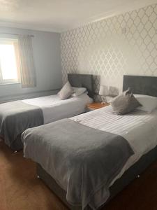 Habitación de hotel con 2 camas y ventana en Tafarn Y Rhos, en Llangefni