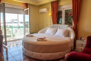 a hotel room with a large bed and a large window at Hotel Astoria in Igoumenitsa