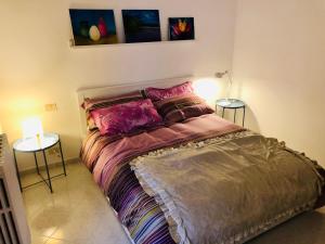 a bed in a room with two tables and two lamps at La casa di Nonna Clo, nel centro di Vasto in Vasto