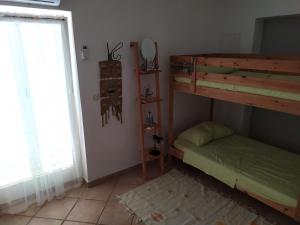 a bedroom with two bunk beds and a window at Sunny Blue Apartament in Nerezine
