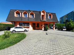 a house with a car parked in front of it at Hotel Senica in Senica