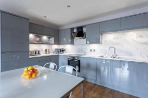 a kitchen with a table with a bowl of fruit on it at Stunning 2 Bed Merchant City Apartment with Residents Parking (Bell 2) in Glasgow