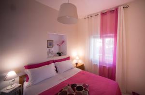 una camera da letto con un letto con una coperta rosa e una finestra di Villa Anna a Vietri