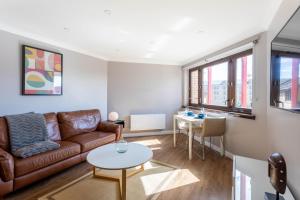 a living room with a couch and a table at Stunning 1 Bed Merchant City Apartment with Parking in Glasgow
