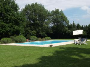 a swimming pool in a yard with two lawn chairs at Villa Ghia in Parma