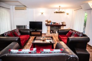a living room with leather couches and a tv at Vila Diamant in Neptun