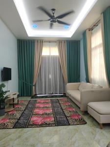 sala de estar con sofá y ventilador de techo en Cikgu CTZ Homestay A, en Kampung Raja