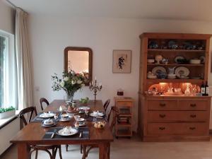 a dining room with a table and a dresser at Bed & Breakfast de Echo in Muiderberg