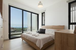 a bedroom with a large bed with a large window at Avalon 1 Villa 14 in Paphos
