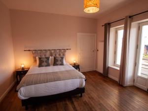 a bedroom with a large bed and two windows at LA GOUTTE D'OR in Avize