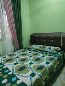 1 cama con manta de flores y sofá de cuero en Cikgu CTZ Homestay A, en Kampung Raja