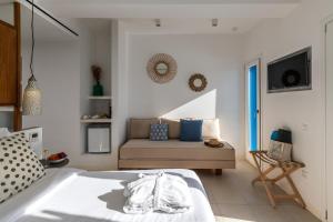 sypialnia z łóżkiem i kanapą w obiekcie Bluetopia Suites w mieście Mykonos