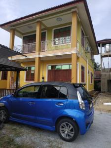 un coche azul estacionado frente a una casa en Cikgu CTZ Homestay A, en Kampung Raja