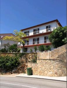 a building on the side of a stone wall at Apartments Marija in Rabac
