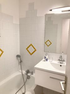 un bagno con un lavandino, una vasca e uno specchio di l'escale a Cogolin