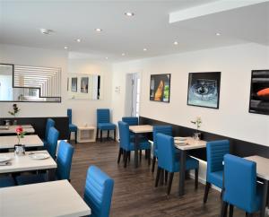 une salle à manger avec des chaises et des tables bleues dans l'établissement Hotel BaWü, à Stuttgart