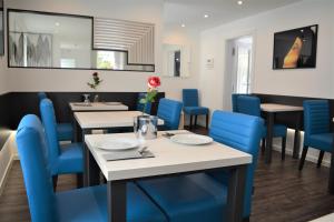 a dining room with blue chairs and tables at Hotel BaWü in Stuttgart