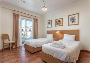 - une chambre avec deux lits, une chaise et une fenêtre dans l'établissement Altura Beach AL2, à Altura