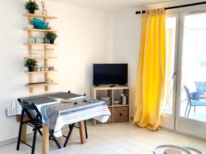 un soggiorno con un tavolo e una televisione di l'escale a Cogolin