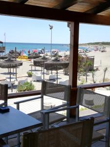 vista para a praia a partir de um restaurante com mesas e cadeiras em Casa delle lantane climatizzata em Villaputzu