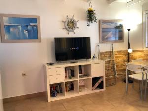 a living room with a tv on a white entertainment center at Apartamentos casa Tia Antonia in Málaga