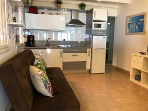 a living room with a couch and a kitchen at Apartamentos casa Tia Antonia in Málaga