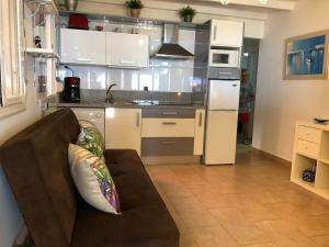 a living room with a couch and a kitchen at Apartamentos casa Tia Antonia in Málaga