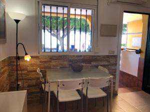 a dining room with a table and chairs and a window at Apartamentos casa Tia Antonia in Málaga