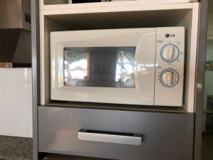 a microwave oven sitting on top of a cabinet at Apartamentos casa Tia Antonia in Málaga