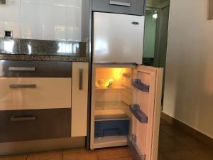 an empty refrigerator with its door open in a kitchen at Apartamentos casa Tia Antonia in Málaga