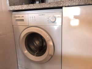 a washing machine in a kitchen next to a counter at Apartamentos casa Tia Antonia in Málaga