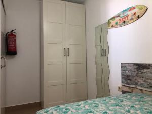 a bedroom with a bed and a surfboard on the wall at Apartamentos casa Tia Antonia in Málaga