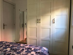 a bedroom with white cabinets and a bed at Apartamentos casa Tia Antonia in Málaga