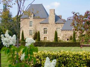 een groot stenen huis met een dak bij Gîte Le Logis - Manoir le Plessix Madeuc in Corseul