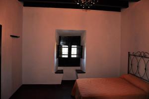 a bedroom with a bed and a window at La Matilla in Puebla del Maestre