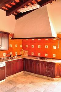 - une cuisine avec des placards en bois et un mur orange dans l'établissement La Matilla, à Puebla del Maestre