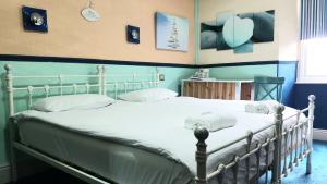 1 dormitorio con 1 cama blanca y paredes azules en Lakes Lodge Windermere, en Windermere