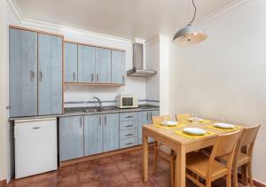 a kitchen with a wooden table and a table and chairs at Altura Beach AL2 in Altura