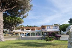 una casa grande con un árbol en el patio en Villa Les Glycines, en Les Issambres