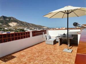 patio con tavolo e ombrellone sul tetto di Apartamentos La Mar Chica a Benalmádena