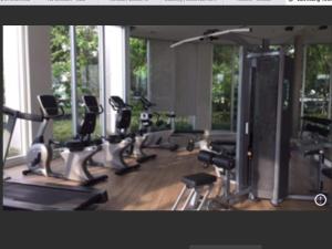 a gym with a row of treadms and elliptical machines at river front in Nonthaburi