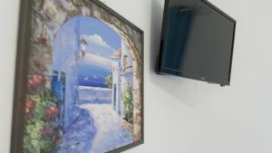 a tv hanging on a wall next to a painting at Pepi's Rooms in Triovasálos